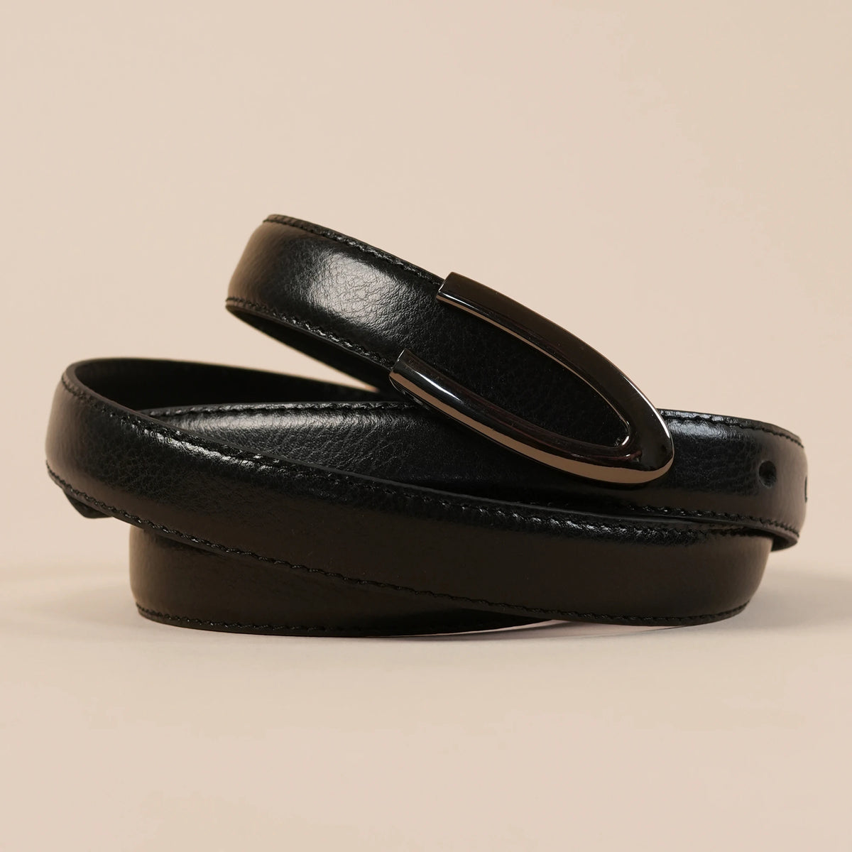 Close-up of the Darci belt's flush open U buckle on black leather