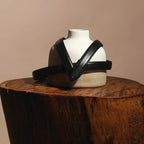 Darci belt draped over a ceramic bust on a wooden stump