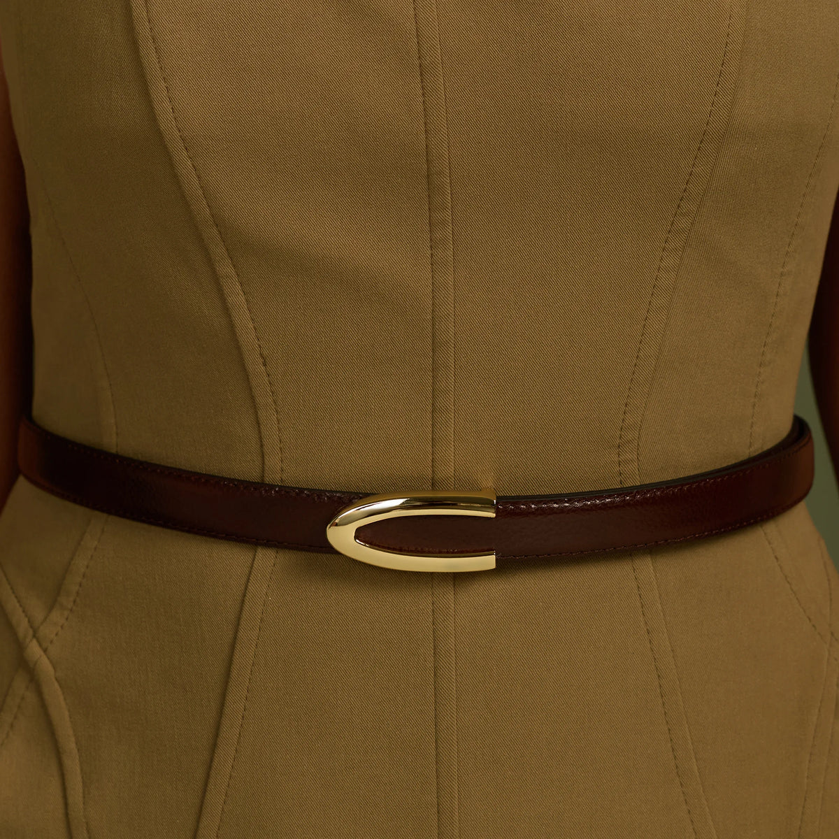 Brown Darci belt with gold buckle worn over an olive dress
