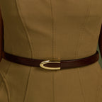 Brown Darci belt with gold buckle worn over an olive dress