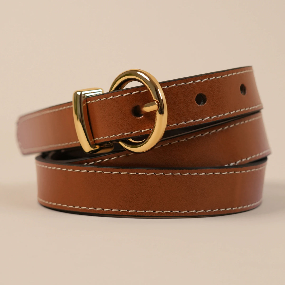 Close-up of the Georgia belt's rounded gold buckle and white stitching