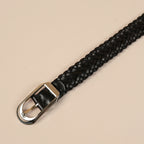 Close-up of the Rio belt's silver buckle on black braided leather