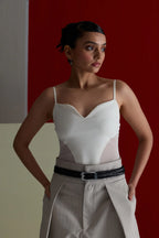 Woman in a white top and grey trousers posing in the black Rio belt