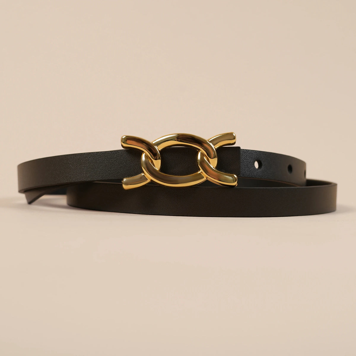 Close-up of the Scarlett belt's gold chain-link buckle on black leather