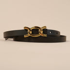 Close-up of the Scarlett belt's gold chain-link buckle on black leather