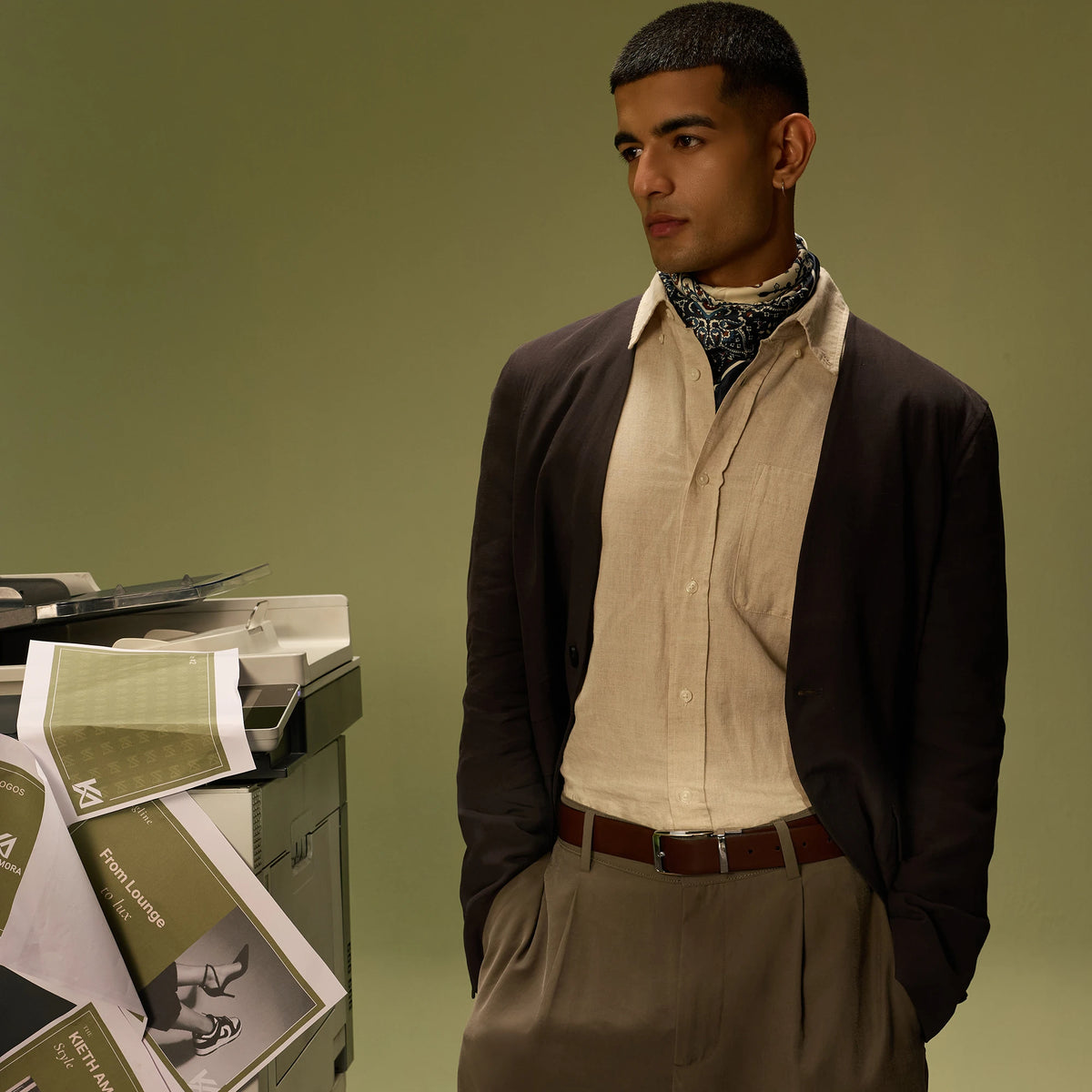 Man in a cream shirt, brown cardigan and bandana wearing the Savora reversible belt